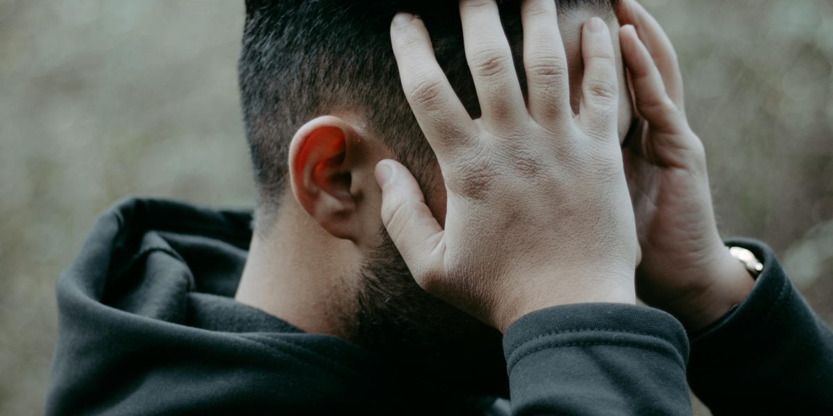 A person experiencing internal anxiety in a group setting, illustrating the isolating nature of social anxiety.