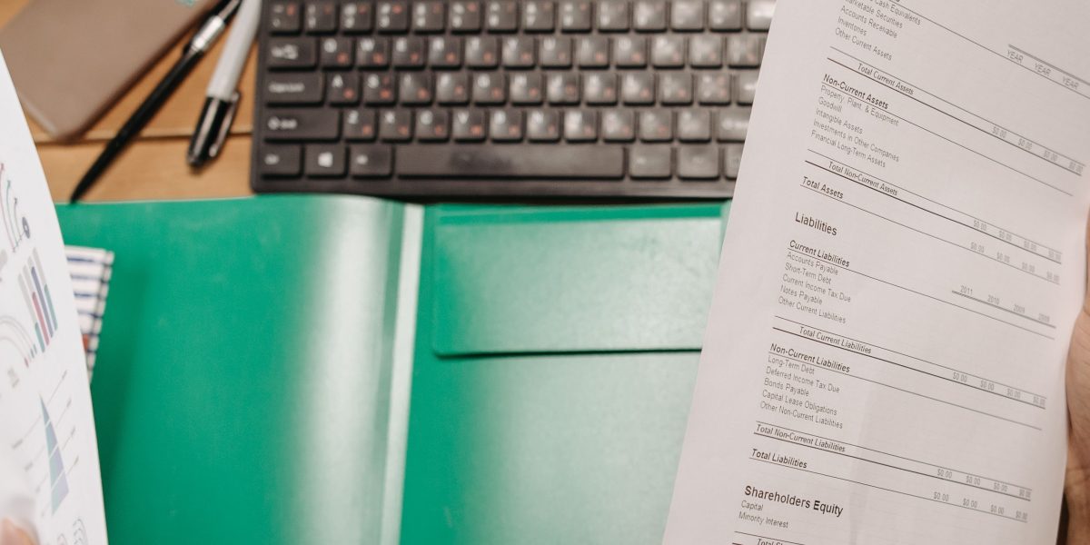 A person sitting at a desk, calmly organizing documents and paperwork, preparing for a planned absence.