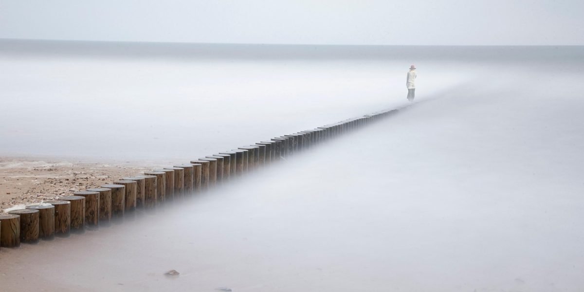 A person in a calm state, possibly meditating or relaxing, as they visualize a peaceful and safe environment.