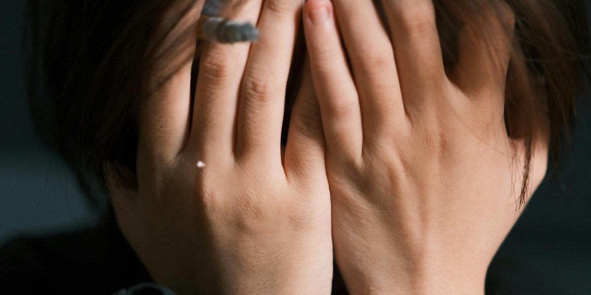 A person experiencing feelings of overwhelm and anxiety in a social setting.