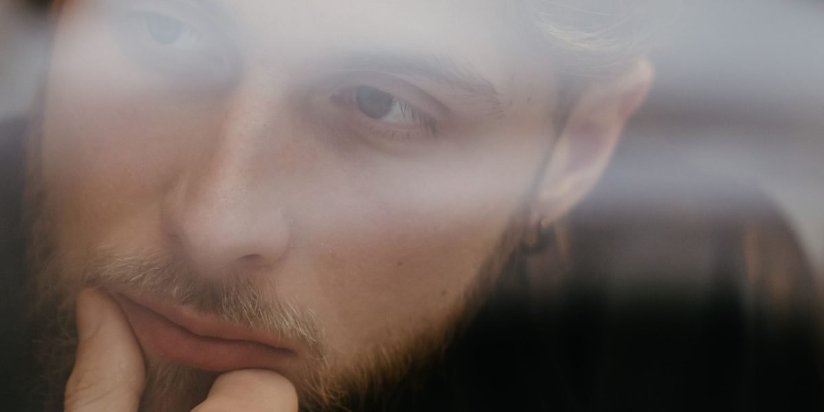 Someone reflecting deeply, perhaps processing thoughts and emotions in a quiet, focused manner.