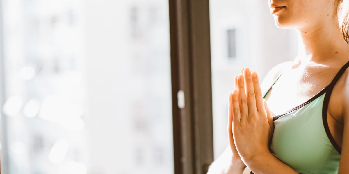 A person actively practicing diaphragmatic breathing with hands placed on the chest and belly to monitor breath movement.