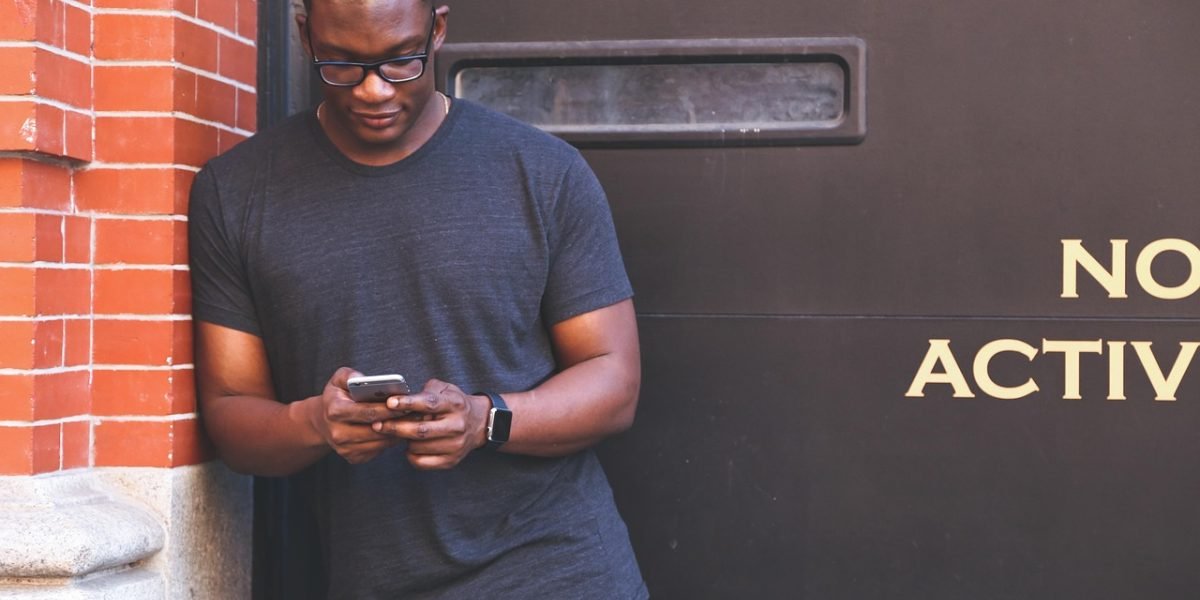 A person gazes at their phone, perhaps contemplating what they see and how it compares to their own life.